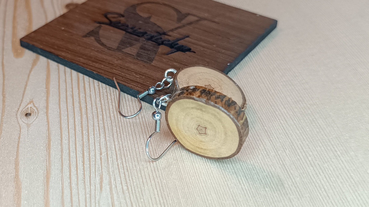 Pendientes artesanales de madera al natural en mano mostrando tamaño real – SerViArte