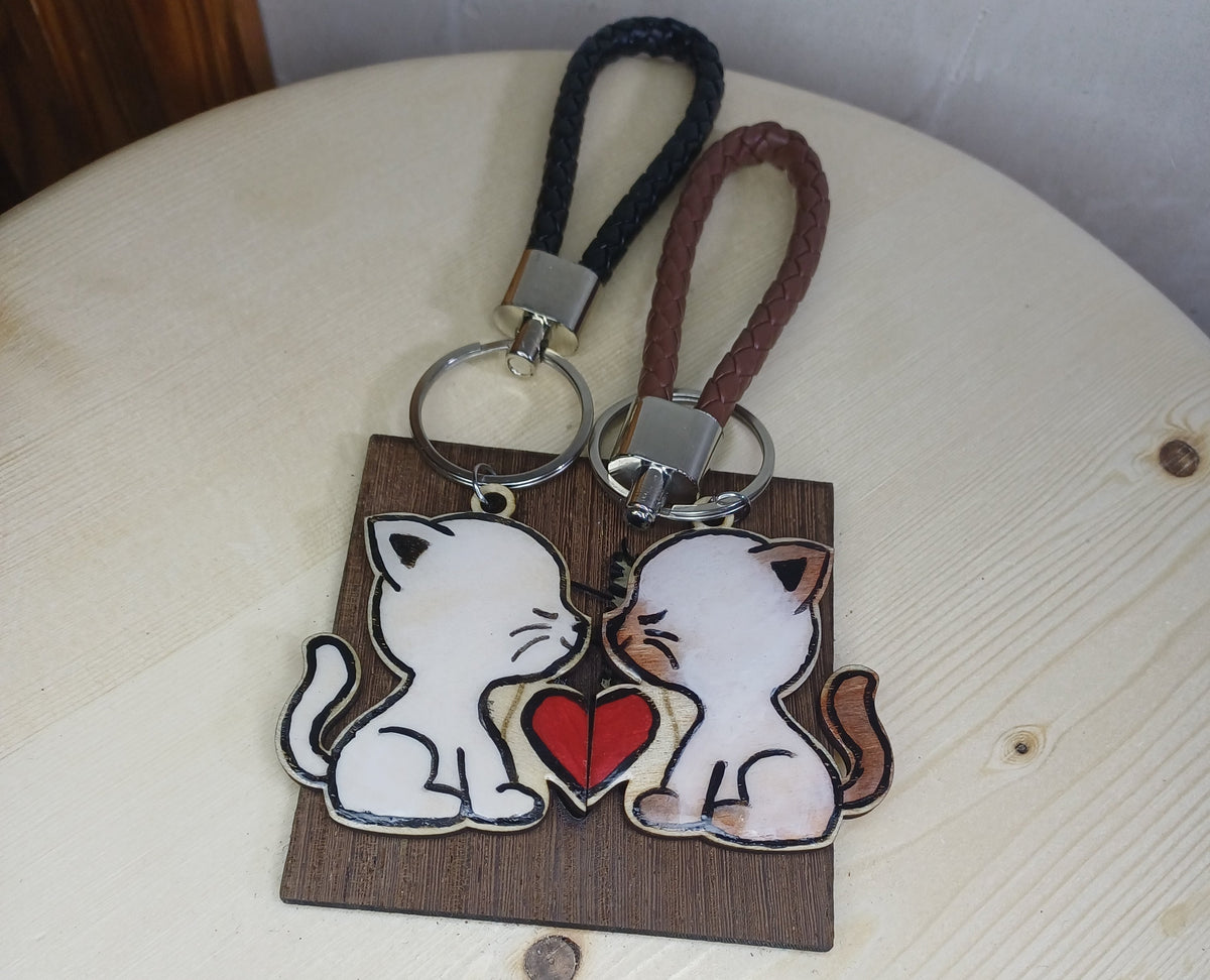 Pack 2 llaveros gatito de madera artesanal sobre superficie SerViArte Segovia