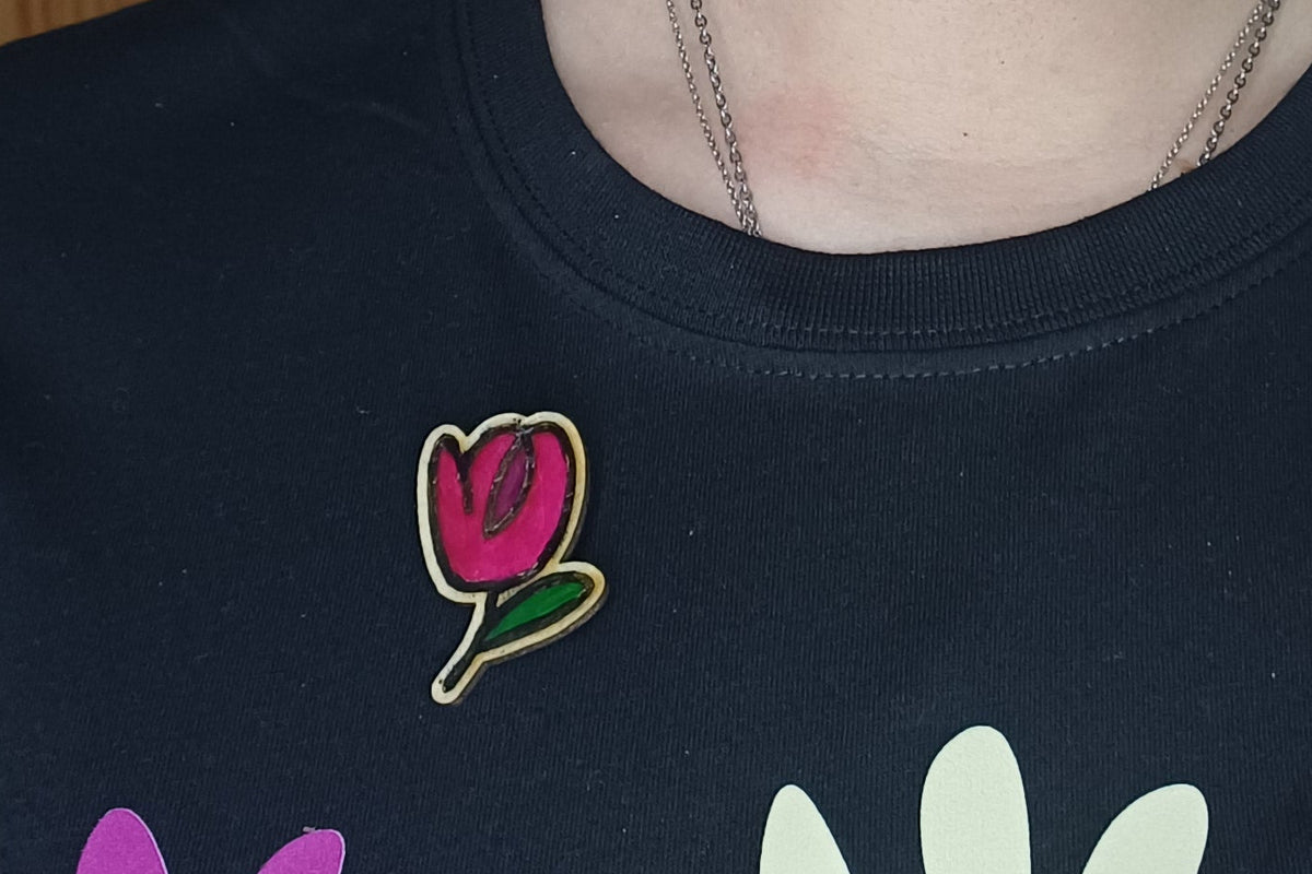 Broches Trama Viva artesanales de madera pintados a mano sobre fondo claro SerViArte
