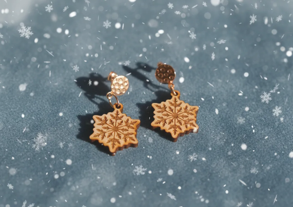 Fotografia de unos pendientes que tienen forma de copo de nieve, hechos con madera