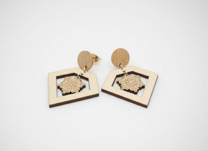 pendientes que tienen una decoracion muy elegante y estetica de un diamante y en su interior un copo de nieve perfectos para navidad