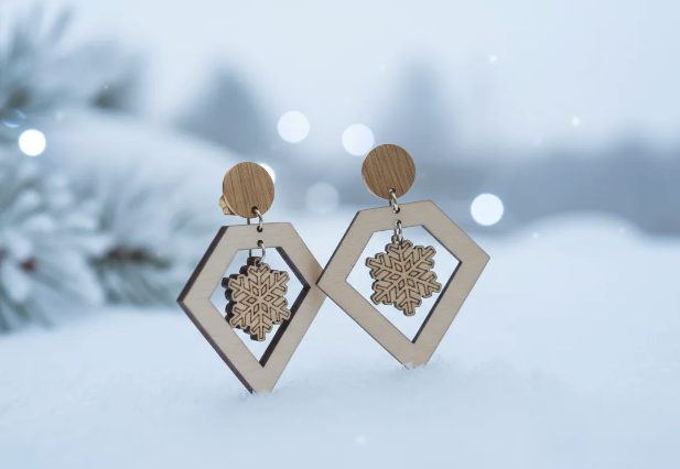 pendientes que tienen una decoracion muy elegante y estetica de un diamante y en su interior un copo de nieve perfectos para navidad