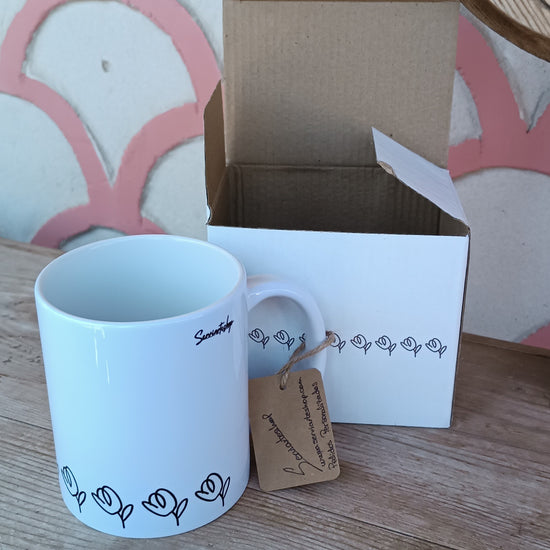 Rotación de la taza “Suspiro de Tulipán”, destacando su diseño en línea continua negra con tulipanes minimalistas, visible alrededor de la base.