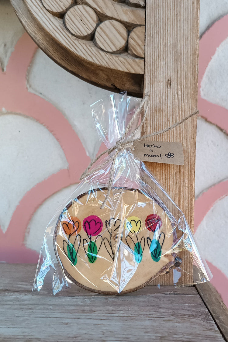 Detalle ilustración posavasos Trama Viva, flores dibujadas a mano sobre madera natural